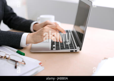 Nahaufnahme des Business Frau Hände Tippen auf Laptop-Computer im weißen farbigen Büro. Stockfoto