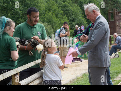 Der Prince Of Wales mit acht Jahre alten Skye Skillen von Colchester Hühner während seines Besuchs in Jimmys Farm in Ipswich, wo er traf das Vertrauen neuer Präsident, Jimmy Doherty, und erfuhr von dem Bauernhof Bildung und seltene Rassen Programm, betrachten. Stockfoto