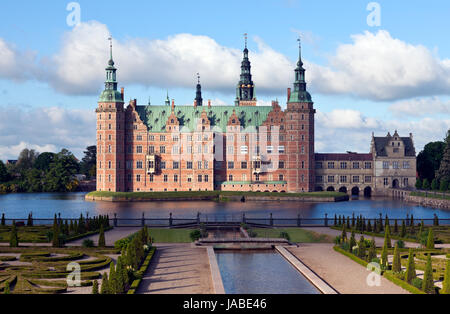 Schloss Frederiksborg im niederländischen Renaissance-Stil und der Garten des Barock. Hillerød, Nordsealand. Morgensonne, Wolken, die mystisches Licht und Schatten werfen Stockfoto