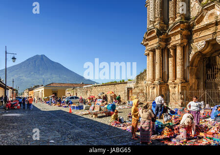 Antigua, Guatemala - 5. Oktober 2014: Wochenende maya Textilmarkt außerhalb El Carmen Ruinen mit agua Vulkan hinter im Unesco Weltkulturerbe Stockfoto