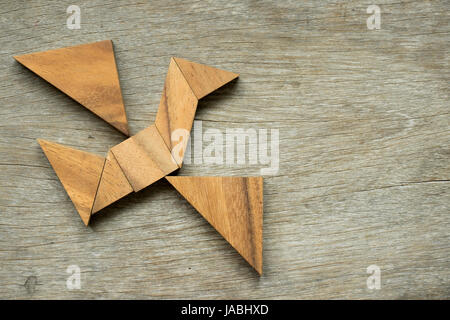 Mann halten Dreieck, Tangram-Puzzle in Vogel-Form zu erfüllen (Konzept für die Freiheit, frei leben oder entdecken Sie neue Welt) Stockfoto