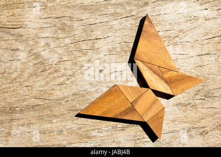 Hölzerne Tangram puzzle in fliegender Schmetterling Form Hintergrund Stockfoto