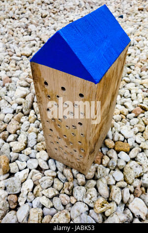 Eine dekorative einsame Bienenhaus aus einem massiven Eiche Holz-Block mit blauen Dach Stockfoto