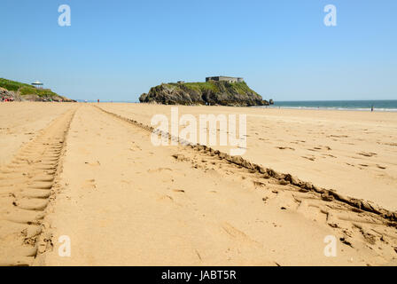 Traktor reifen Markierungen am Strand von South Beach in Tenby. Zentrale ist St Catherine's Island Pembrokeshire. UK. Stockfoto