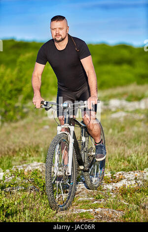 Porträt der Athlet Mann auf Mountainbike auf dem Hügel in der Sommersaison. Stockfoto