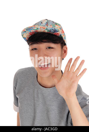 Glücklicher asiatische Teenager in einem Closeup Bild unter Verzicht auf seine Hand mit einer Mütze auf dem Kopf, für weißen Hintergrund isoliert. Stockfoto