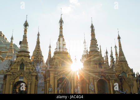 Die Sonne versinkt hinter Pagoden an der Shwedagon-Pagode in Yangon (Rangoon), Myanmar (Burma) Stockfoto