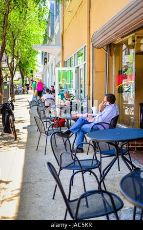 Ein Blick auf einem Gehsteig in der Innenstadt von Tampa, FL mit Läden und Restaurants mit Sitzgelegenheiten im Freien mit Menschen Essen und entspannen am Mittag Stockfoto