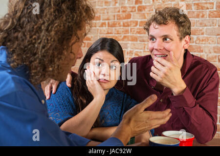 Fasziniert Freunde hören Mann im café Stockfoto