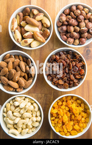 Verschiedenen Nüssen und Rosinen in Schüssel auf Holztisch. Stockfoto