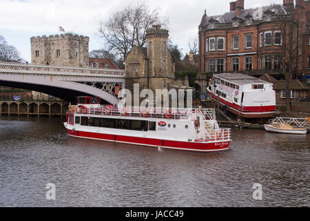 2 Sportboote - 1 Segeln vorbei an den anderen, aus Wasser auf Helling, repariert und renoviert, 1 Mann - Fluss Ouse, York, England, UK. Stockfoto