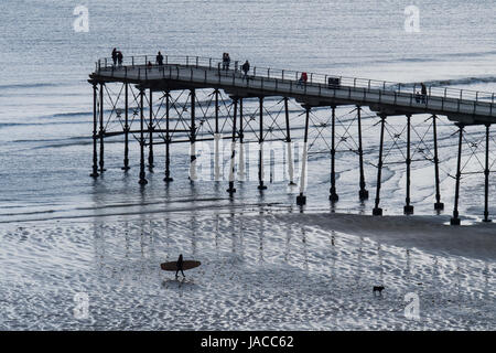 Hohen Blick des Menschen auf viktorianischen Vergnügen Pier, ragt ins Nordsee auf grauen Frühling Tag - Saltburn-by-the-Sea, North Yorkshire, England, GB, UK. Stockfoto