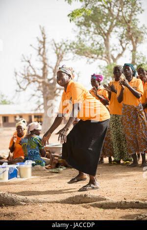 Mitglieder der SILC Frauengruppe (Spar- und Kreditvergabe innergemeinschaftlichen) tanzen zusammen während einer Besprechung Upper East Region, Ghana. Stockfoto