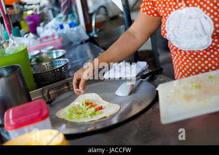 Thai Roti Pfannkuchen vorbereiten. Traditionelle Art der Zubereitung südostasiatischer Crepes. Stockfoto