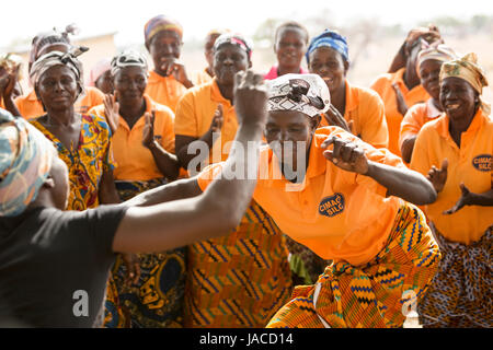 Mitglieder der SILC Frauengruppe (Spar- und Kreditvergabe innergemeinschaftlichen) tanzen zusammen während einer Besprechung Upper East Region, Ghana. Stockfoto