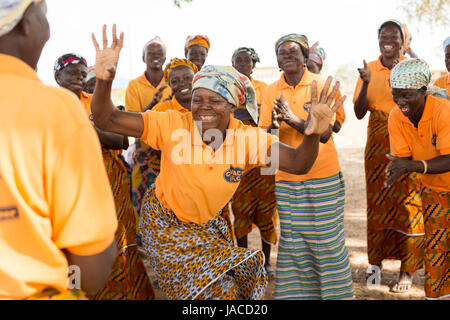 Mitglieder der SILC Frauengruppe (Spar- und Kreditvergabe innergemeinschaftlichen) tanzen zusammen während einer Besprechung Upper East Region, Ghana. Stockfoto