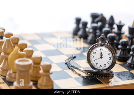 Vintage Tasche Uhr und Schach Stücke auf Schachbrett Stockfoto