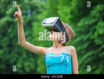 Kleines Mädchen mit VR-Brille im park Stockfoto