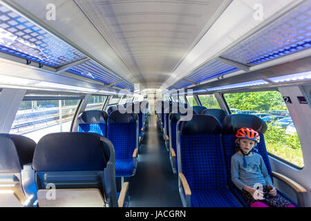 Regionalzug Deutsche Bahn Mädchen im Wagen Deutschland Zug Europa Deutscher Personenzug Kind allein im Fahrradhelm Innenwagen Pendlerzug Stockfoto