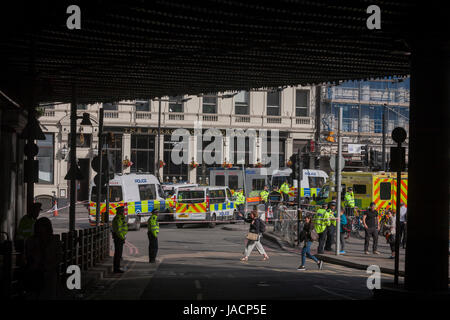 36 Stunden nach der London Bridge und Borough Market Terroranschlag, die Hauptstadt zurück zur Normalität und Londoner zurück zu ihrem ersten Tag zu arbeiten, damit Polizisten mit Wegbeschreibungen helfen, da Straßen für den Verkehr und Fußgänger verwenden, auf Montag, 5. Juni 2017, im Stadtteil South London Southwark, England noch geschlossen sind. Sieben Menschen wurden getötet und viele andere Links mit lebensverändernden Verletzungen- aber der britischen Geist des Trotzes und weiterhin mit täglichen Lebens erträgt. Stockfoto