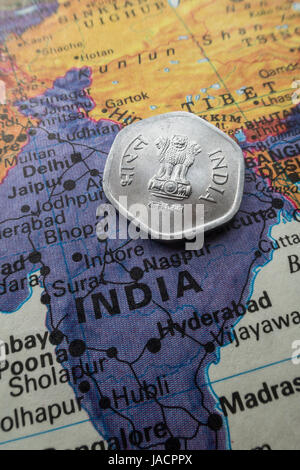 Indische Rupie-Münze auf Welt-Karte-Stillleben Stockfoto