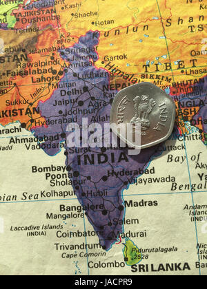 Indische Rupie-Münze auf Weltkarte Stockfoto