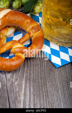 Ein Glas Mit Bier, Brezeln Und Once Hopfendolden Auf Einem alten Rustikalen Holztisch Stockfoto