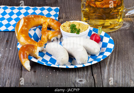 Typisch Bayerische Oktoberfest Brauches Mit Weißwurst, Senf, Brezeln Und Einem Kühlen Bier Auf Einem Blau-Weißem Pappteller Stockfoto