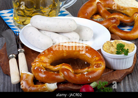 Typisch Bayerische Oktoberfest Brauches Mit Weißwurst, Senf, Brezeln Und Einem Kühlen Bier Auf Einem Rustikalem Holztisch Stockfoto