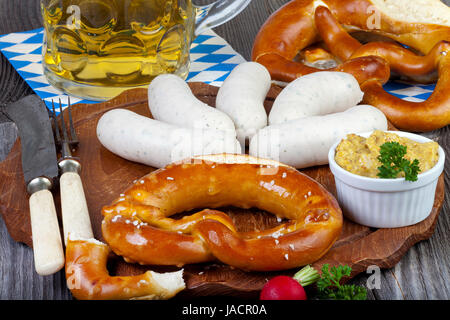 Typisch Bayerische Oktoberfest Brauches Mit Weißwurst, Senf, Brezeln Und Einem Kühlen Bier Auf Einem Rustikalem Holzti Stockfoto