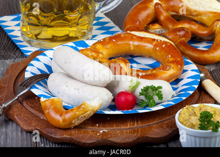 Typisch Bayerische Oktoberfest Brauches Mit Weißwurst, Senf, Brezeln Und Einem Kühlen Bier Auf Einem Rustikalem Holzti Stockfoto