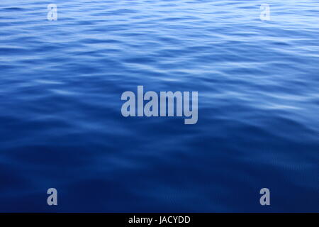 Wellen auf blauem Wasser Hintergrund Stockfoto