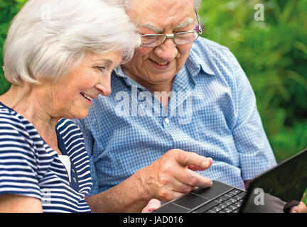 Gerne älteres Paar mit Laptop im freien Stockfoto