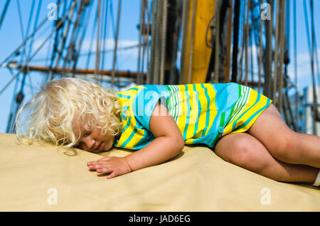 Das kleine Mädchen schlief auf dem Deck eines Segelbootes Stockfoto