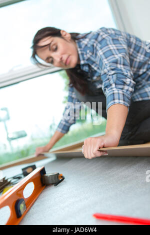 Frau passend Teppich in ihrem Wohnzimmer Stockfoto