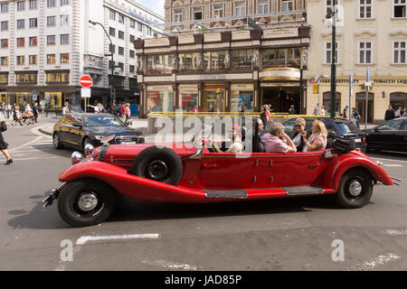 Touristen, die sightseeing in einer Oldtimer Alfa Romeo Spider-Limousine auf eine Tour durch Prag Stadtzentrum Stockfoto