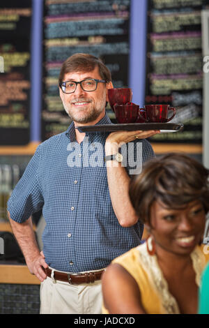 Mann mit Brille, servieren von Getränken an die Kunden Stockfoto