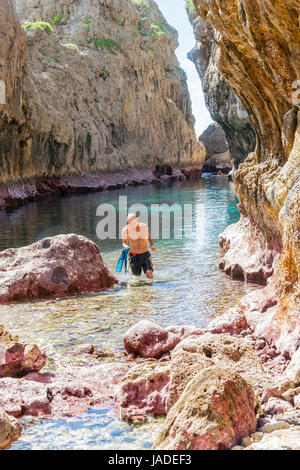 Schöne ruhiges türkises tropischen Wasser umgeben von verschiedenen Farben auf Felswände des Matapa Abgrund Niue nach Schwimmen verlässt der Mann. Stockfoto