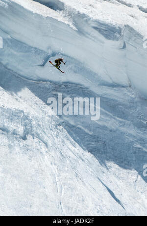 Extremsport: Skifahrer springen von einem überhängenden Schneegrat in den Beartooth Mountains, Montana, USA Stockfoto