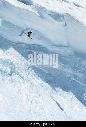 Extremsport: Skifahrer springen von einem überhängenden Schneegrat in den Beartooth Mountains, Montana, USA Stockfoto