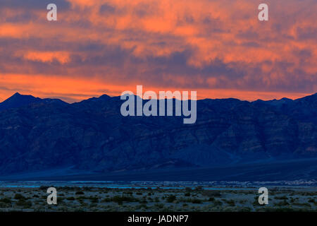 Dabei schossen das Nachleuchten der Sonnenuntergang leuchten die Wolken über die Panamint Range auf der Westseite des Death Valley Nationalpark, Kalifornien, USA. Stockfoto