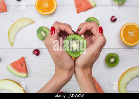 Draufsicht des Mädchens Hand, auf weißen Desktop mit Früchten platziert. Stockfoto
