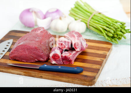 rohes Rindfleisch und Schweinerippchen mit Spargel und Kräutern bereit, Kochen Stockfoto