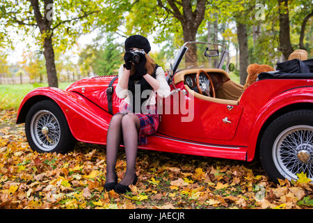 Junge Frau fotografieren mit Auto auf Hintergrund Stockfoto