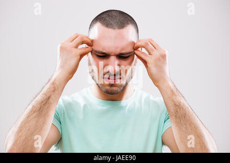 Porträt eines jungen Mannes, der Kopfschmerzen hat. Stockfoto
