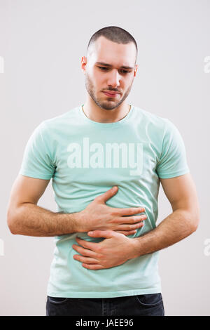 Junger Mann hat Schmerzen in seinem Magen. Stockfoto