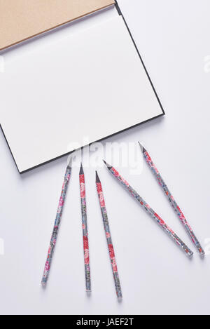 Erhöhte Ansicht von Bleistiften auf dem notebook Stockfoto