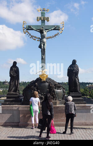 Touristen auf der Karlsbrücke Blick auf die Statuen des Heiligen Kreuz und Golgatha, Prag Stockfoto