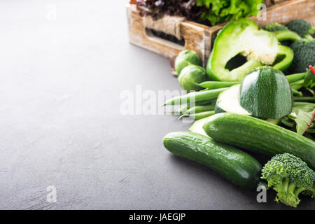 Mini-Gurken mit sortierten grünes Gemüse, Salat, Brokkoli, Erbsen und Rosenkohl auf braunen Stein Tischplatte. Gesunde Ernährung-Konzept mit Kopie spa Stockfoto