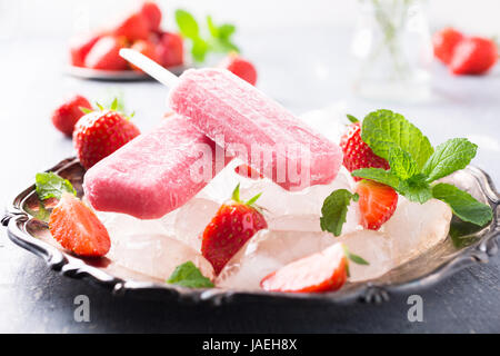 Hausgemachte Erdbeer Eis am Stiel auf Metallplatte mit Beeren und Eis. Sommer-Food-Konzept. Stockfoto